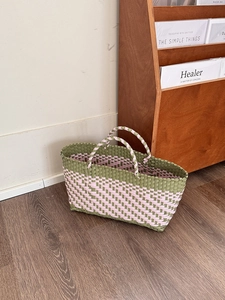 Detail of hand-woven tote bag in green and pink checkerboard with sturdy dual handles