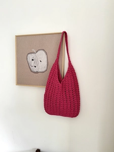 Detail of rose pink crochet hobo bag showing intricate wavy openwork knit pattern