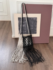 Detailed close-up of handmade bohemian fringe bags in black and beige woven cotton