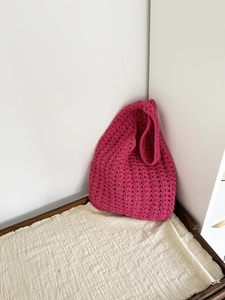 Close-up of handmade magenta crochet beach tote showing intricate V-stitch weaving detail