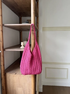 Detail of rose red hand-woven shoulder bag with intricate 3D crochet texture