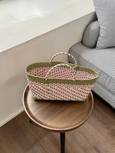 Detail of army green and pink woven tote bag showing durable plastic craft texture