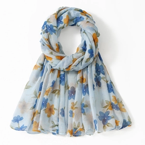 Detail of light blue floral voile scarf with delicate orange and navy flower patterns