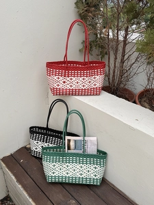 Detail of woven beach tote bags showing PE texture in red, black, and green colors