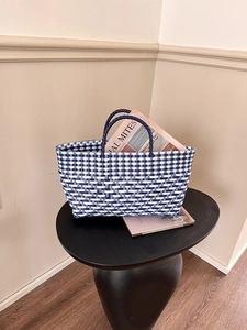 Detail of blue and white hand-woven basket bag showing intricate plastic mesh texture