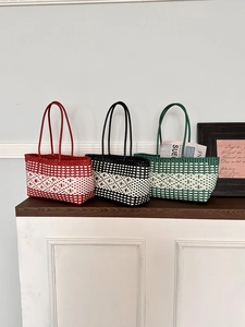 Detailed view of handmade woven tote bags in red, black, and green checkered patterns