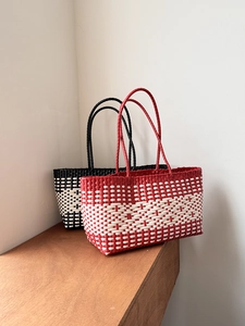 Detail of hand-woven tote bags in red-white and black-white checkered patterns