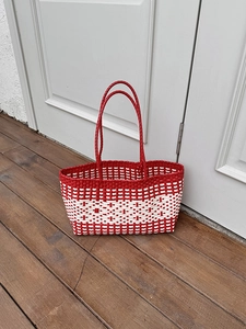 Detail of red and white woven tote bag with geometric patterns for beach vacations