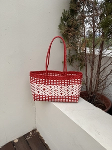 Close-up of red and white woven tote bag with durable lattice texture for beach use