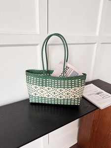 Close-up of green and beige woven tote bag detailing texture and round handles
