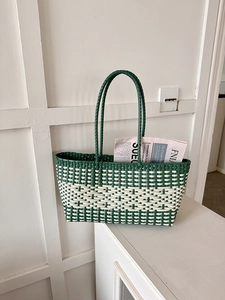Detail of green and white checkered woven tote bag showing durable plastic mesh texture