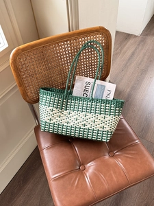 Detail of green and white checkered woven tote bag on a vintage chair for beach vacation