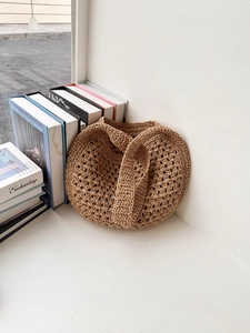 Détail d'un sac cabas en paille tissé à la main avec des motifs délicats au crochet ajouré