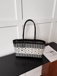 Close-up of black and white woven tote bag texture with round top handles