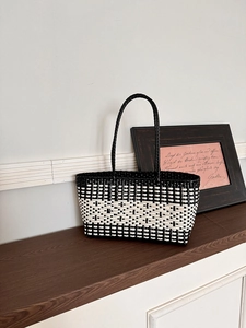 Detailed close-up of handmade black and white woven tote bag with resin mesh texture