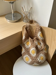 Handmade crochet tote bag with large daisy flower patterns and natural woven texture