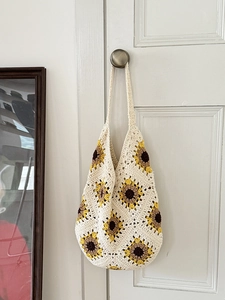 Handmade crochet tote bag with yellow sunflower patterns and long shoulder straps
