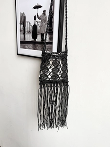 Handmade black macrame crossbody bag with long fringes and bohemian diamond weave pattern