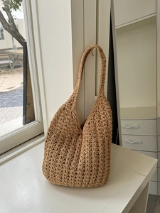Handcrafted woven straw shoulder bag with crochet cutout design for beach vacation style