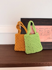 Detail of hand-woven hollow fishnet mini tote bags in mustard yellow and lime green colors