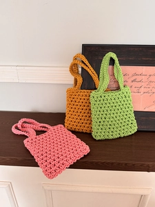 Close-up of hand-woven mesh texture on pink, yellow, and green summer beach bags