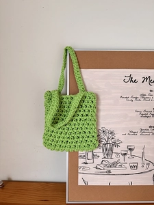 Detail of green crochet hollow mesh handbag texture hanging on a cork board