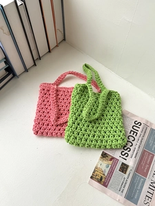 Detail of pink and green hand-woven hollow fishnet crochet tote bags for beach vacation