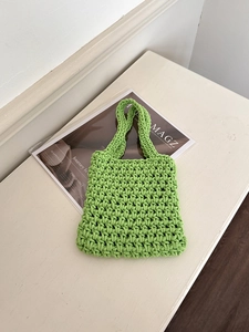 Macro view of bright green handmade woven handbag with textured mesh knit details