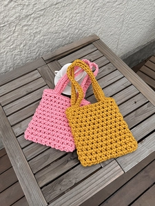 Close-up of pink and yellow hand-woven hollow fishnet texture on summer beach bags