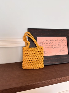 Detail of hand-woven hollow fishnet texture on bright yellow cotton crochet handbag