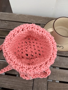 Detail of pink hand-woven mesh bag showing cross-stitch texture and interior capacity