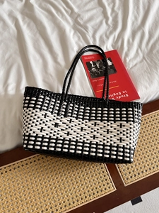 Chic black and white woven tote bag with geometric patterns for beach or daily style