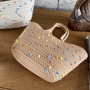 Bohemian style woven cotton hand bag featuring colorful pom-poms and rustic design