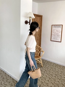 Detail of white textured puff-sleeve top with chic back tie and blue wide-leg jeans