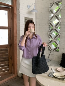 Close-up of black straw woven tote bag texture with minimalist casual outfit in cafe