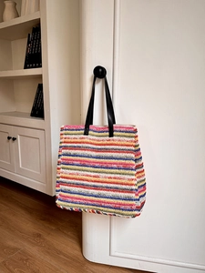 Colorful striped crochet tote bag with black leather handles for summer beach vacations