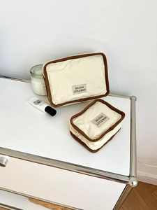 Σετ νεσεσέρ από καμβά σε κρεμ χρώμα με καφέ τελείωμα και υφασμάτινη ετικέτα στη μέση
