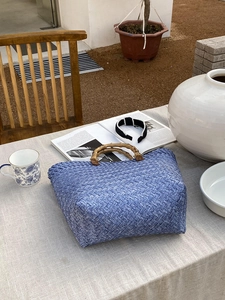 Detail der blauen gewebten Einkaufstasche mit Bambusgriffen und strukturierter Beutelform
