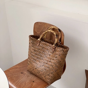 Detail der vintage braunen geflochtenen Tragetasche mit Bambusgriffen und Metallnieten