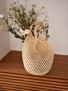 Detailed view of the hollow crochet weave and natural texture on the woven beach bag