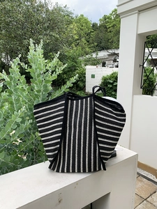 Detailed close-up showing the knit texture and vertical stripes of this woven beach tote