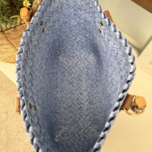 Top view of blue and white woven tote bag showing spacious interior and leather fasteners