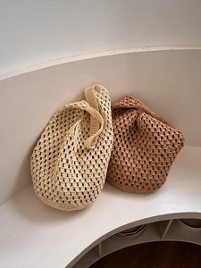 Detail of hand-woven crochet mesh texture on large beach bags in beige and brown colors