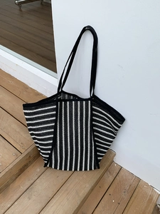 Detailed texture of black and white striped woven tote bag with durable shoulder straps