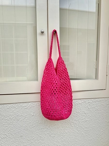 Handmade magenta woven net shoulder bag with openwork crochet design for beach vacation