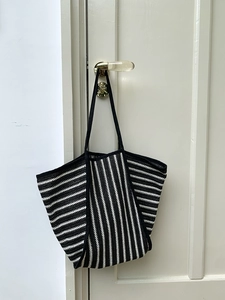 Detail view of woven striped tote bag showing fine texture and black and white pattern