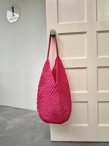 Detail of rose pink hand-woven crochet tote bag showing hollow hollow mesh and soft texture