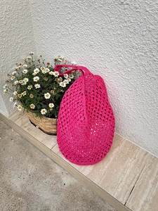 Close-up of fuchsia handmade crochet tote bag featuring intricate openwork knit texture