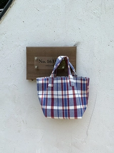 Close-up of durable woven striped canvas tote bag with blue white and red plaid pattern