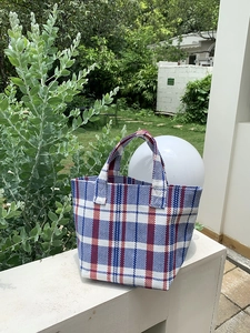 Detail of colorful striped canvas tote bag showing reinforced handles and woven texture